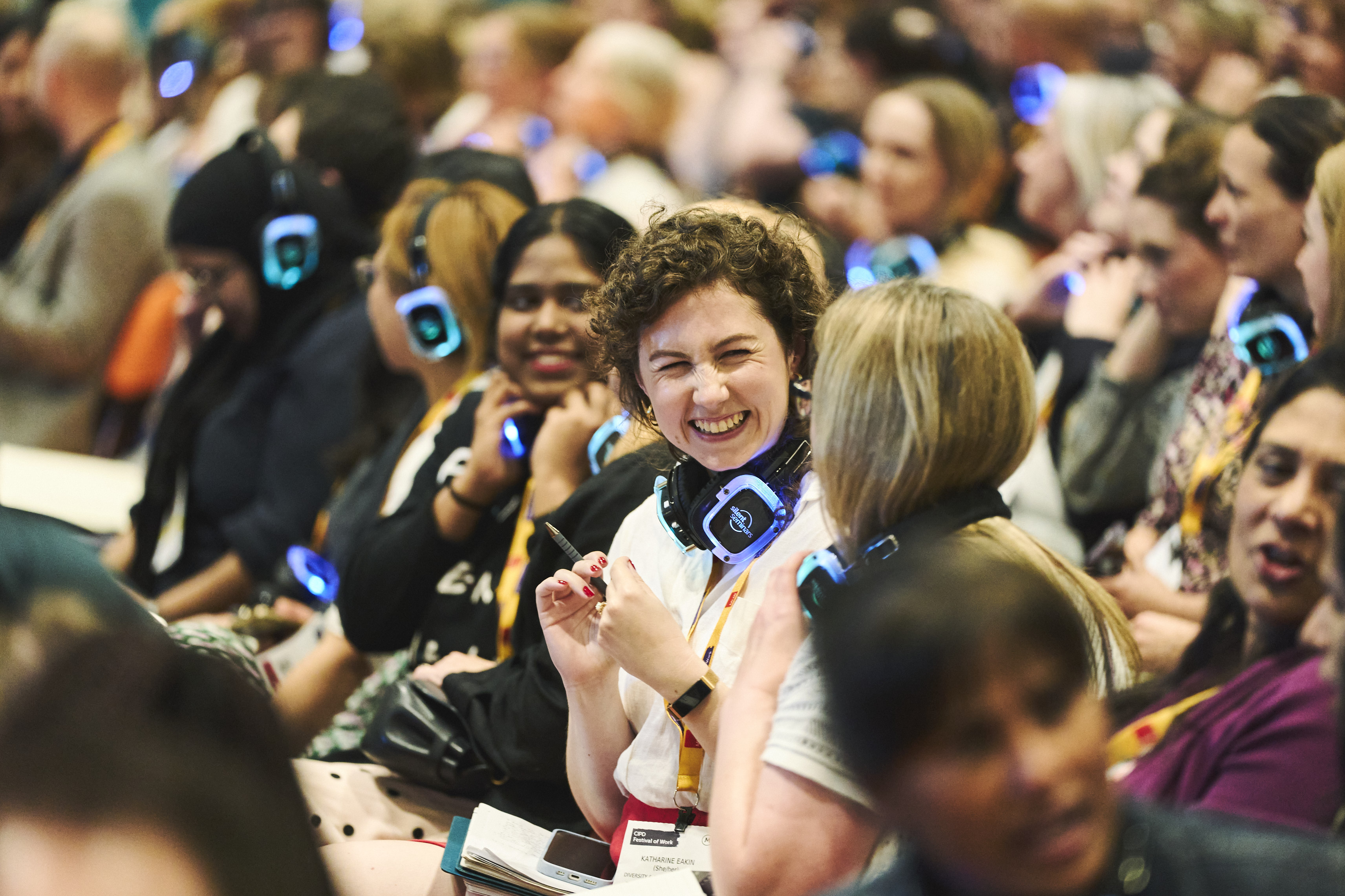 audience member smiling at the person sat next to her at a conference